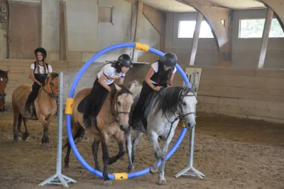 Groupe d'enfants souriant pendant un stage vacances équitation au centre Equi 22 à Yffiniac